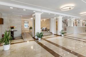 a lobby with potted plants in a building at Hotel Condor in Mamaia