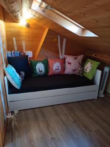 a couch with pillows on it in a room at Appartement mansardé cocooning in Saint-Martin-Vésubie