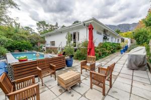 a house with a patio with chairs and a pool at 8 Sleeper, 4 Bedroom Home in Franschhoek in Franschhoek