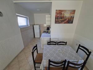 a kitchen and dining room with a table and chairs at Apartman Leka in Donji Bogdašići