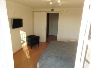 Un dormitorio con una cama y un televisor en la pared. en Lisbon Belém Guesthouse, en Lisboa