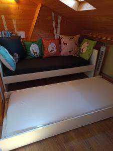 a couch in a room with pillows on it at Appartement mansardé cocooning in Saint-Martin-Vésubie +2 photos