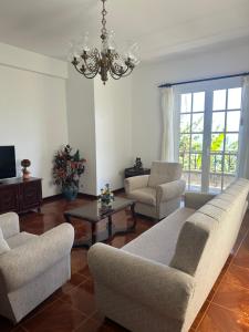 a living room with chairs and a chandelier at Casa 52 in Machico