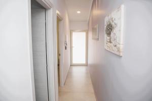 a hallway with white walls and a hallway with a door at Dai Massari in Villaggio Azzurro +21 photos