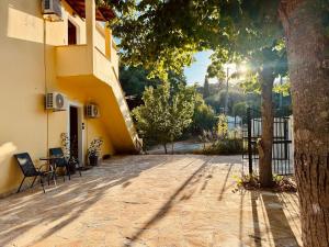 a courtyard of a building with chairs and a tree at Seaside Garden House 7 in Dassia