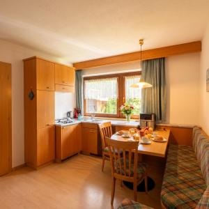 a kitchen and dining room with a table and a couch at Garni Renzler in Rasun di Sopra