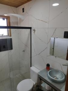 a bathroom with a toilet and a sink and a shower at Cabana Mais Natureza in Santo Amaro da Imperatriz +49 photos