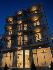 a tall building with windows and balconies at night at SkyHouse Batumi in Batumi