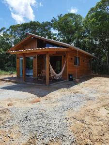 a log cabin with a hammock in front of it at Cabana Mais Natureza in Santo Amaro da Imperatriz