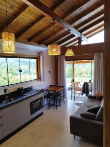 a kitchen and living room with a couch and a table at Cabana Mais Natureza in Santo Amaro da Imperatriz