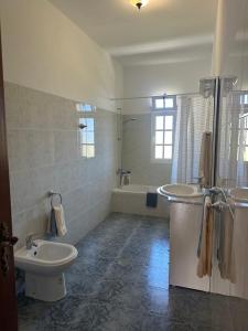 a bathroom with a sink and a toilet and a tub at Casa 52 in Machico +24 photos
