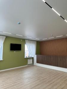 a large room with a flat screen tv on a wall at Moskovskaya in Atyrau