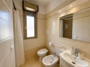 a bathroom with a toilet and a sink and a mirror at Anthea - Timavo apartament 1 in Lignano Sabbiadoro