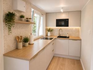 a kitchen with white cabinets and a sink at Lake House Mierzyn in Mierzyn