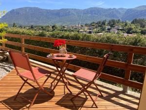 a table and two chairs on a deck with a view at Le Gîte Martin in Quillan