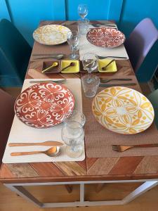 a wooden table with plates and utensils on it at Le Gîte Martin in Quillan