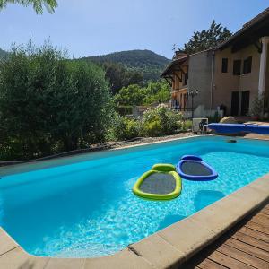 a swimming pool with two rafts in the water at Le Gîte Martin in Quillan