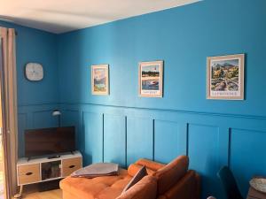 a blue living room with a couch and a tv at Le Gîte Martin in Quillan