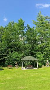 a gazebo with a picnic table and benches in a field at Noclegi U Renaty Solina in Solina