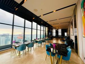 a restaurant with tables and chairs and large windows at GOLDEN Services Suites At Star KLCC in Kuala Lumpur