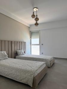a bedroom with two beds and a chandelier at Meditranee Sea View in Tangier +32 photos