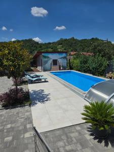 a swimming pool in front of a house at Apartment Sunrise in Batina