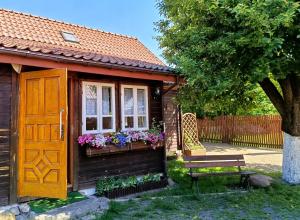 a small house with a bench and a window at Domek Zapiecek in Białowieża +24 photos