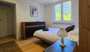 a bedroom with a bed and a table with a lamp at Agroturystyka w Folwarku Uradz in Tarmno