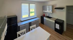 a kitchen with a counter and a table and a window at Agroturystyka w Folwarku Uradz in Tarmno