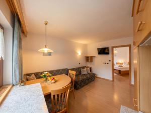 a living room with a table and a couch at Garni Renzler in Rasun di Sopra