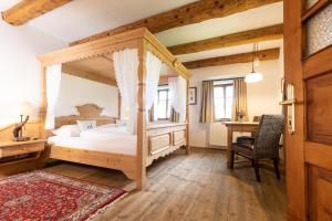 a bedroom with a canopy bed and a desk at Genussgut Krispel in Neusetz