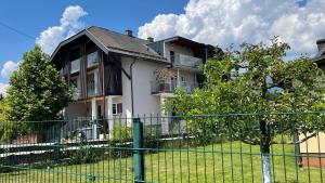 a white house with a fence in front of it at CASA VIVA Panorama Suites in Villach