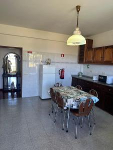 a kitchen with a table and chairs and a refrigerator at Casa 52 in Machico