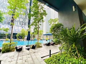 people sitting under umbrellas near a pool in a city at GOLDEN Services Suites At Star KLCC in Kuala Lumpur