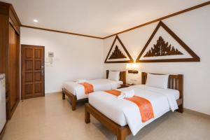 a hotel room with two beds in it at Onnicha Hotel Phuket in Phuket