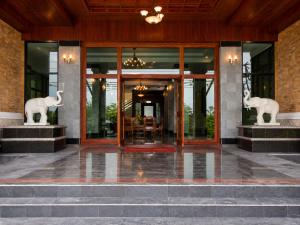 an entrance to a building with two statues of elephants at Onnicha Hotel Phuket in Phuket