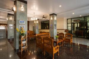 a dining room with chairs and a table with flowers at Onnicha Hotel Phuket in Phuket