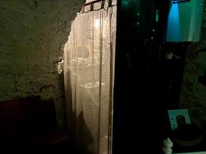 a window with a curtain in a dark room at THE OLD CELLAR no shower! in Locarno
