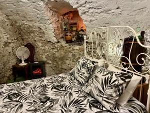 a bedroom with a bed in a stone wall at THE OLD CELLAR no shower! in Locarno +15 photos