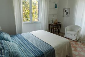 a bedroom with a bed and a chair and a window at Borghese Magnolia Suite in Rome
