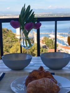 a table with two bowls and a vase with flowers at Puig Rom Pau Vila in Roses