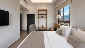 a bedroom with a large white bed and a window at Be Batroun in Batroûn