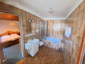 a bathroom with a sink and a toilet and a tub at Garni Renzler in Rasun di Sopra +51 photos