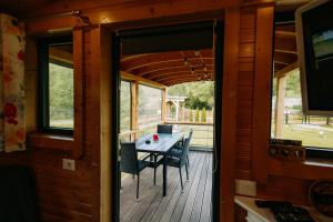 a room with a table and chairs on a deck at La Casuta din Ciocanesti Exclusive in Ciocăneşti