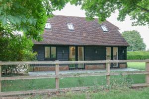a house with a wooden fence in front of it at Little Larks Barn in Felsted Station