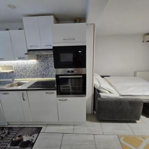 a small kitchen with a microwave and a bed at Pri tetki 2 in Kranj