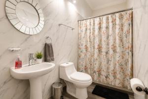 a bathroom with a toilet sink and a shower curtain at Alameda Suites & CAS - Centro Monterrey in Monterrey +50 photos