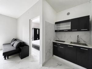 a kitchen with a sink and a bed in a room at Anthea - Loft Elegans in Lignano Sabbiadoro