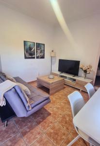 a living room with a couch and a flat screen tv at La Voreta in Villajoyosa