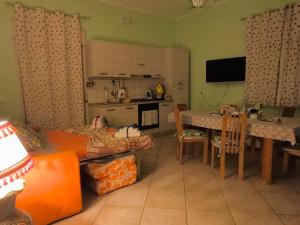 a living room with a kitchen and a dining room at Rainbow Apartment in Scordia